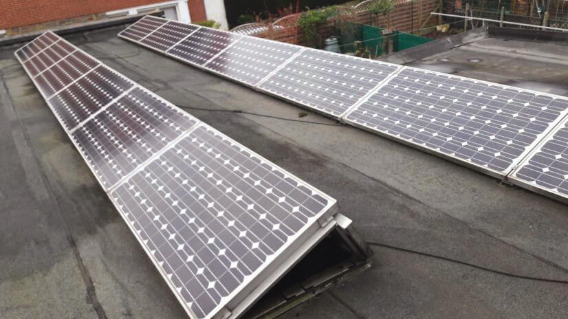 Panneaux solaires photovoltaïques placés sur un toit plat maintenus en place par un lestage
