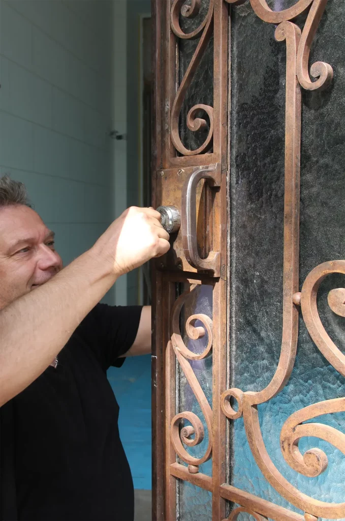 Une artisan répare la serrure d'une porte Beaux-Arts